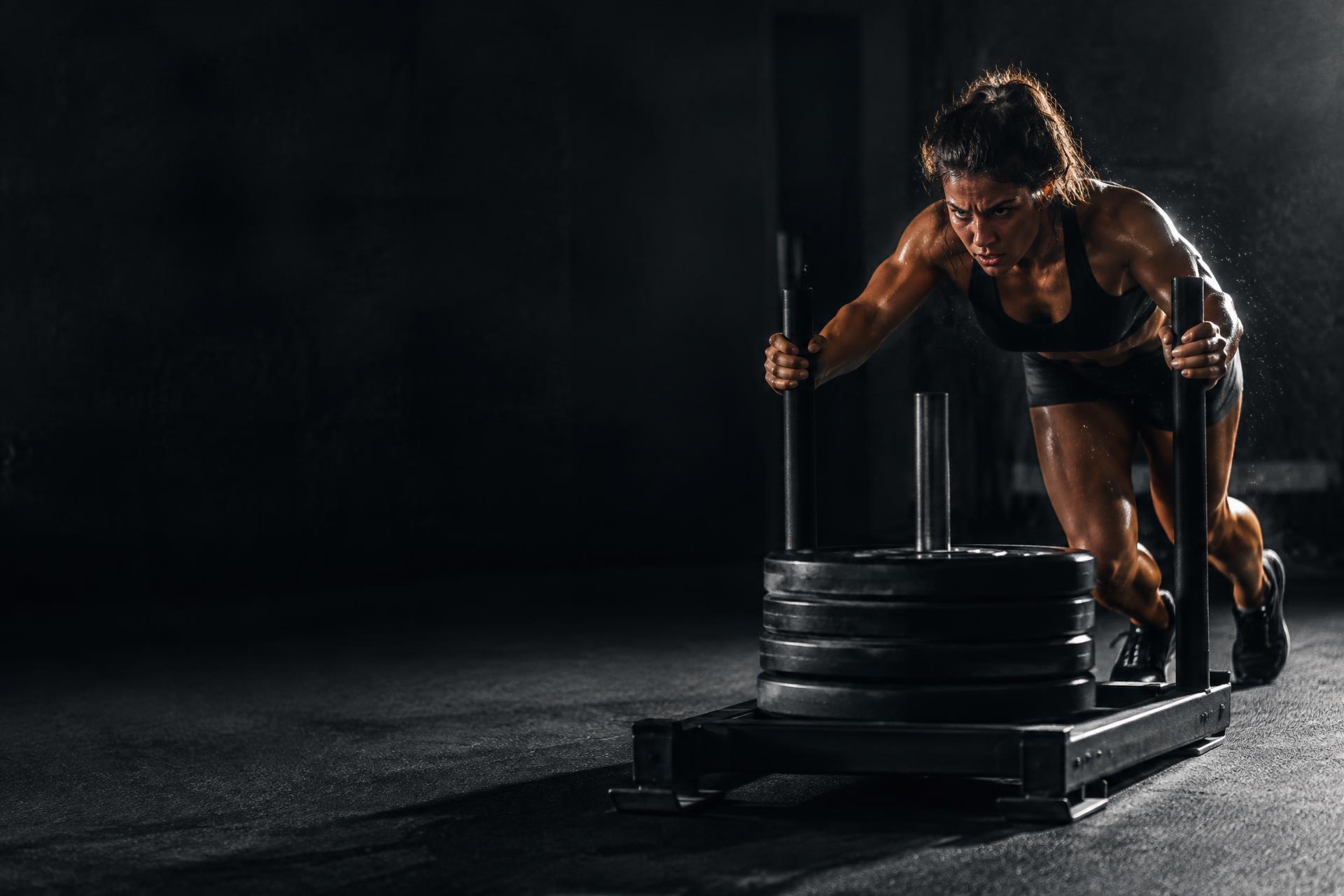 Athlete pushing a weighted sled at full intensity